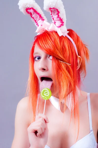 stock image Woman easter bunny on gray background with orange hair