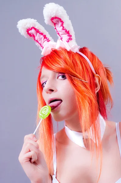 stock image Woman easter bunny on gray background with orange hair