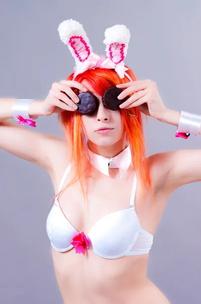 オレンジ色の髪と灰色の背景で女性のイースターのウサギ — ストック写真