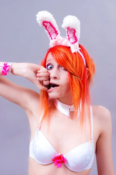 stock image Woman easter bunny on gray background with orange hair