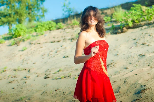 Женщина в красном платье на побережье — стоковое фото