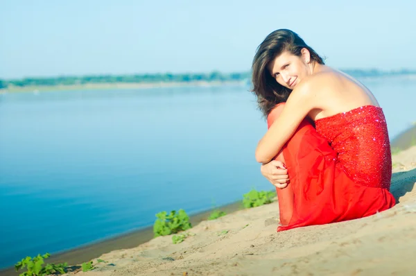 Mulher de vestido vermelho na costa — Fotografia de Stock
