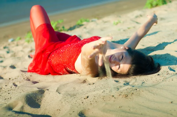 女孩穿着红裙子在海岸上 — 图库照片