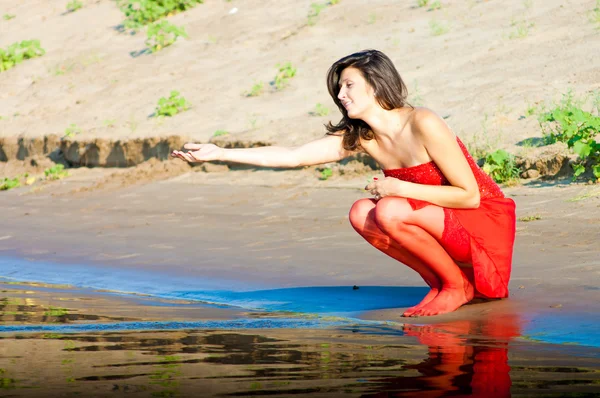 Mujer vestida de rojo en la costa —  Fotos de Stock