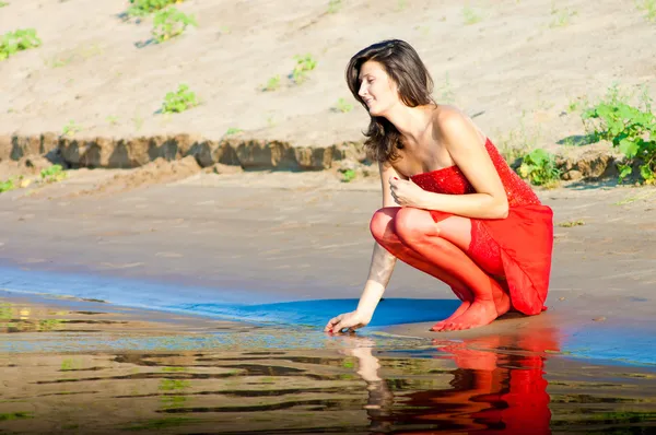 在海岸上的红色衣服的女人 — 图库照片