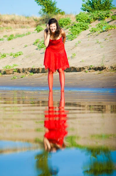 Mujer vestida de rojo en la costa —  Fotos de Stock