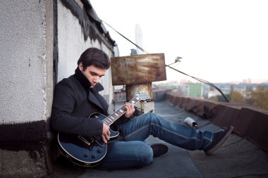 adam çatıda gitar