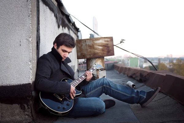 Man with a guitar on the roof — Stock Photo, Image