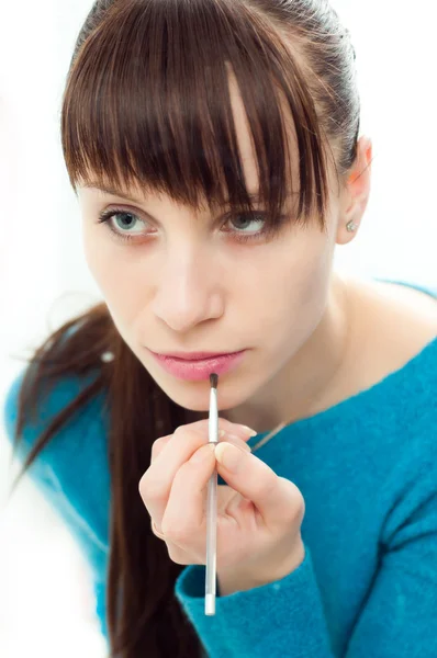 Young girl doing makeup in the mirror — Stock Photo, Image