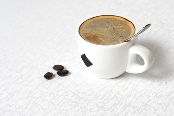 白いテーブル クロスにコーヒーのカップ — ストック写真