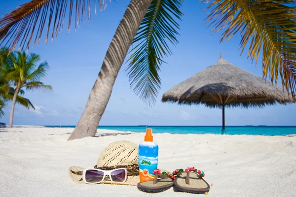Bril, hoed, sandalen onder een palm — Stockfoto