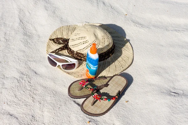 Hut, Brille und Sandalen liegen auf Sand — Stockfoto