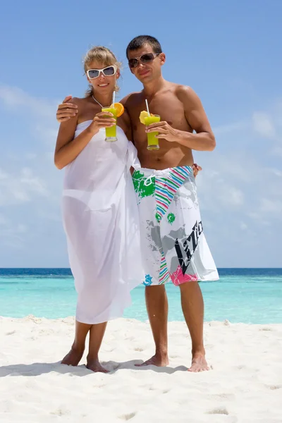 快乐的年轻夫妇在沙滩上与鸡尾酒 — 图库照片