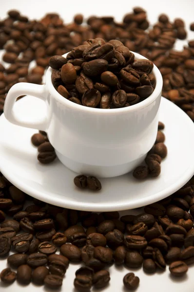 Witte beker met koffiebonen geïsoleerd op witte achtergrond — Stockfoto