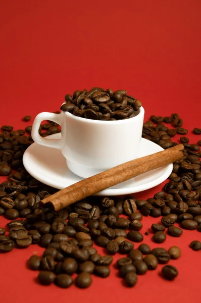 Pohár Kávová Zrna Skořice Červeném Pozadí — Stock fotografie