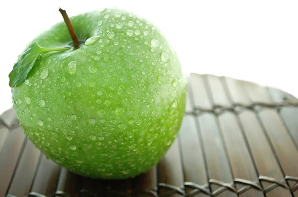Зеленое яблоко с каплями воды — стоковое фото