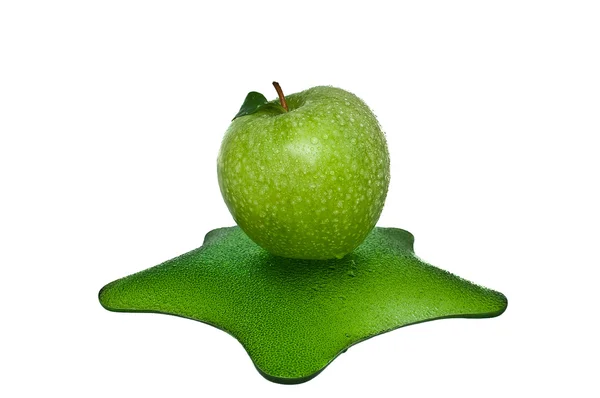 Зеленое яблоко с каплями воды на зеленой тарелке — стоковое фото