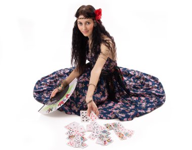 Young gypsy tells fortunes by playing cards clipart