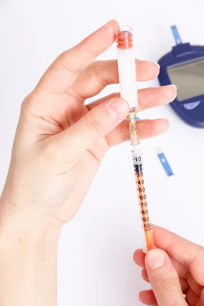 女的手中注射器胰岛素与血糖仪的类型 — 图库照片