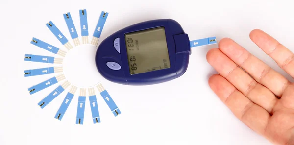 Niveau van de bloedsuiker op glucose meter met diabetische artikelen Stockfoto