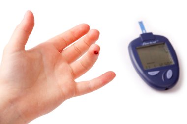 Çocuk hurma ile bir parmak ve aygıt üzerinde beyaz bir arka plan izole kan glikoz düzeyi ölçümü için kan damlacık
