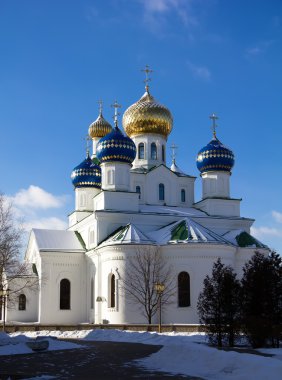 Christian orthodox church with brilliant domes against the blue sky in the winter in a sunny day Belarus Bobruisk clipart