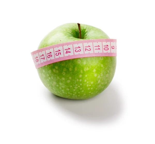 stock image Green apple and measuring tape of the tailor isolated on white