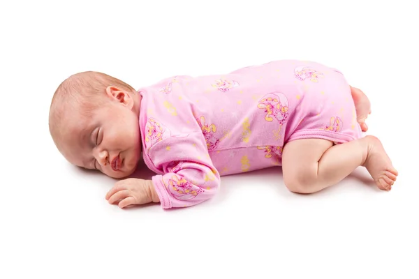 De slapende pasgeboren babymeisje in roze geïsoleerd op een witte achtergrond Stockafbeelding