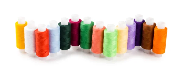 Spools multi-colored threads located a wave isolated on a white background — Stock Photo, Image