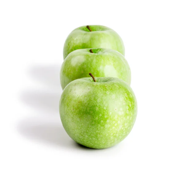 3 dojrzałe i soczyste zielone jabłka znajdujące się w linii na białym tle — Zdjęcie stockowe
