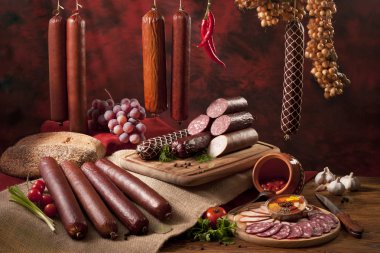 A composition of different sorts of sausages on the table clipart