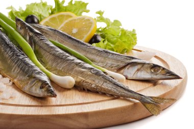 A composition with smoked saira fish (cololabis saira) on wooden plate isolated on white. Closeup clipart