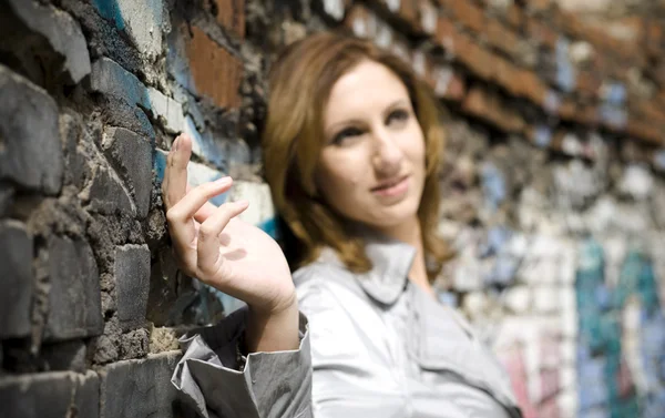Junge Frau Gegen Eine Ziegelmauer Fokus Auf Die Hand — Stockfoto