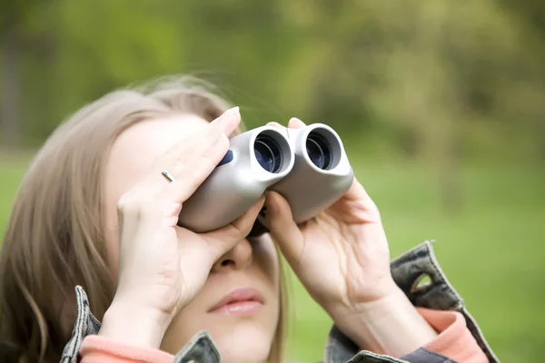 年轻女子用双筒望远镜在森林里寻找 — 图库照片