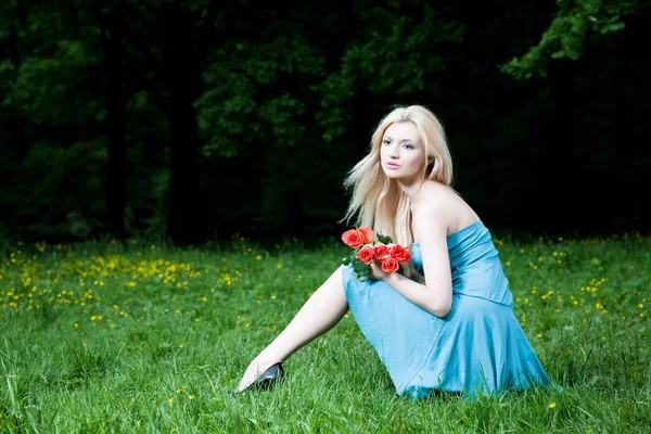 草の上に座っている金髪のきれいな女性 — ストック写真