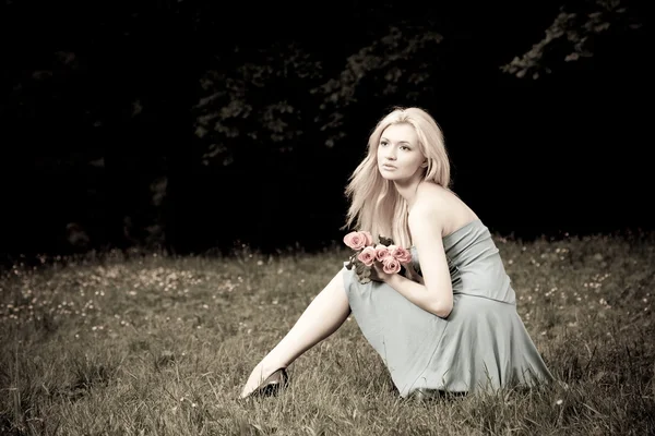 草原の上に座っているきれいな女性 — ストック写真