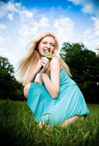 在天空背景上吃棒棒糖的搞笑女人 — 图库照片