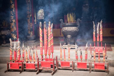 Chinese Temple filled with smoke from burning incenses. New Year's Eve. Ho Chi Minh, Vietnam clipart