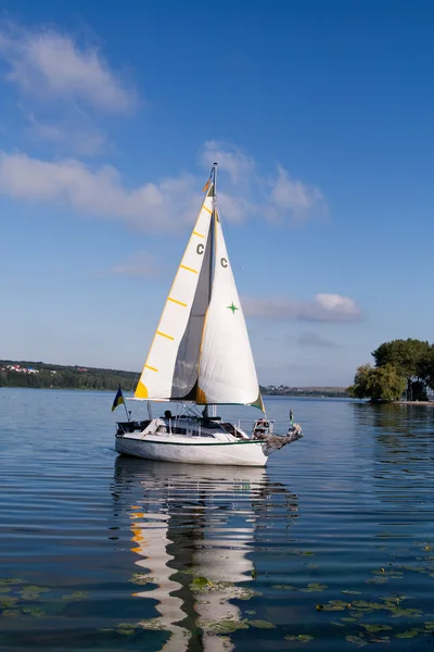 stock image A yacht with white sails floating in the lake