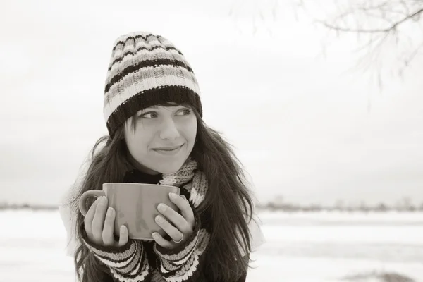 Kız gülümsüyor ve bir fincan holding — Stok fotoğraf