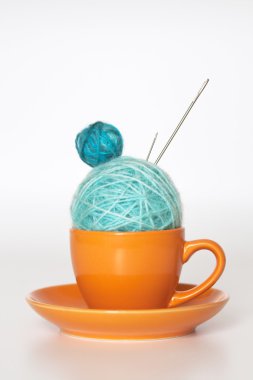 Orange cup with balls of yarn clipart