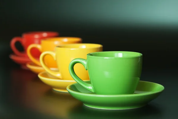 Vier Farbige Tassen Auf Schwarzem Hintergrund — Stockfoto