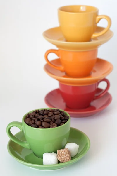 Vier Bunte Tassen Mit Zucker Und Kaffeebohnen Auf Weißem Hintergrund — Stockfoto