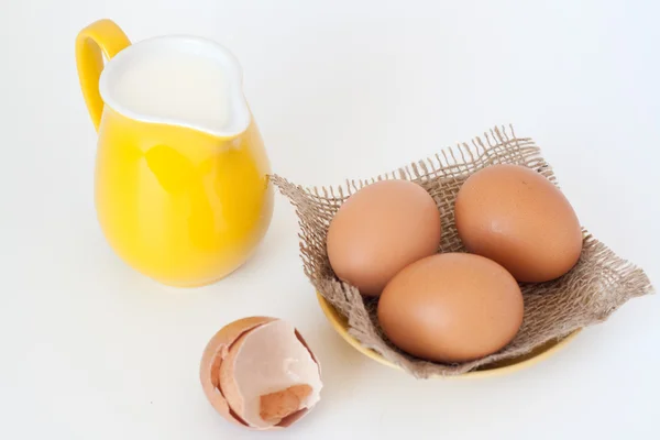 牛奶和鸡蛋在白色背景上的投手 — 图库照片