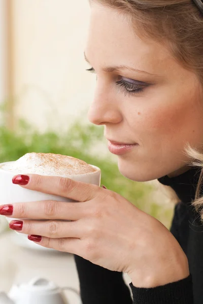 Porträtt av en ung blond skönhet med en kopp cappuccino — Stockfoto