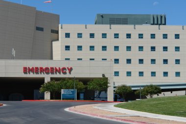 Modern hospital building in front of Emergency entrance. clipart