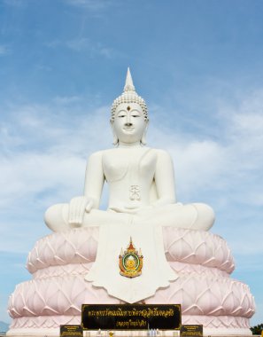Mavi gökyüzü ile beyaz bir Buda heykeli.