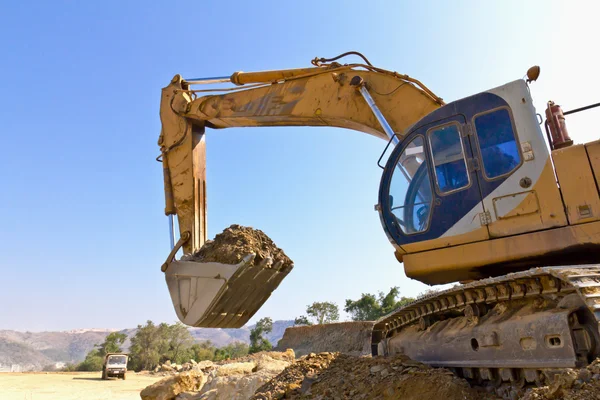Back hoe vehicle on a pile of dirt — Stock Photo, Image