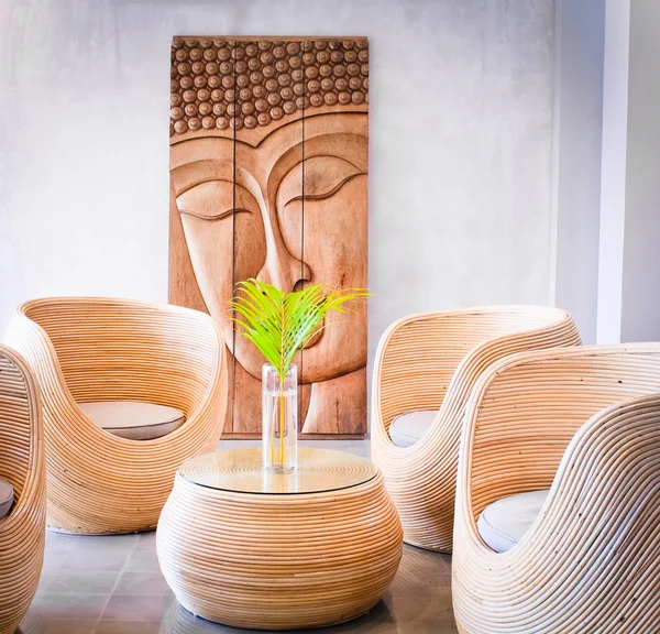 Ein Tropischer Innenhof Mit Holzstühlen Tisch Und Wanddekoration lizenzfreie Stockbilder