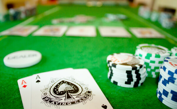 View of poker table with pocket aces, stack and dealer button